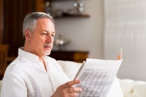 57754594 - portrait of a mature man reading a newspaper